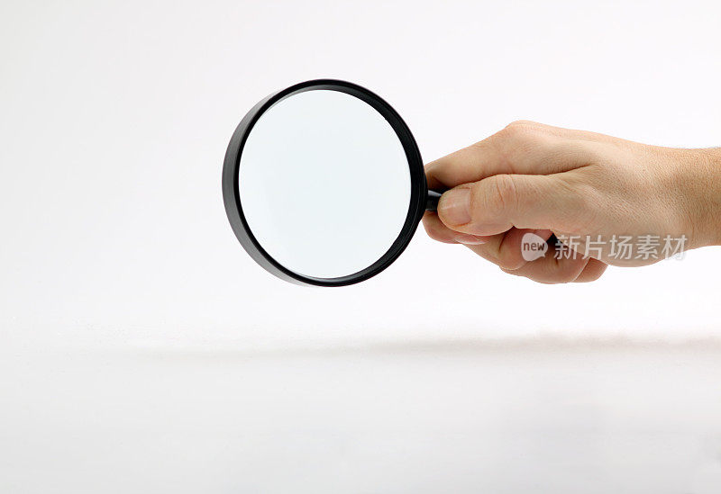 Hand holding magnifying glass